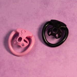 Pink and black inverted chastity cages on fabric